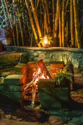 a fireplace with a fire in front of it at Moksha eco villa Ella in Ella