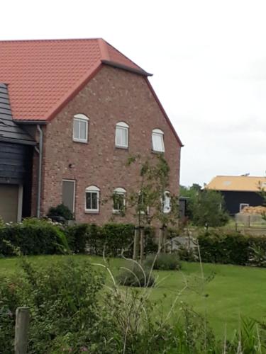 a large brick house with white windows and a yard at de Paardekracht in Serooskerke