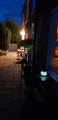 un patio nocturno con sillas y sombrilla en The Vine B & B, en South Thoresby