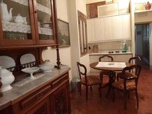 a kitchen with a table and chairs and a table with dishes at Finestra Dell'Angelo in Pienza