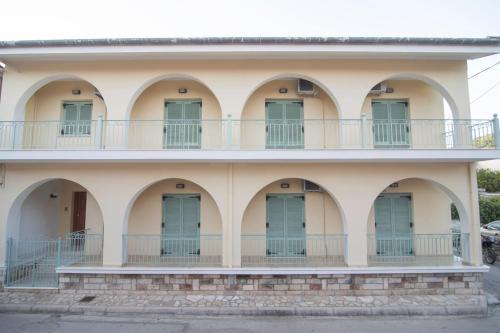 a building with arches and blue doors at Katerina's House in Vathi, Ithaka