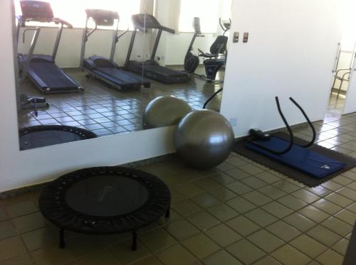 a gym with a bunch of exercise equipment on the floor at Hotel Flat Bassano Vaccarini in Ribeirão Preto