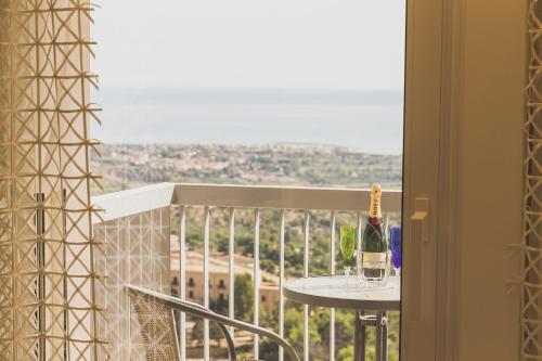 a bottle of wine sitting on a table on a balcony at Hedoné Design Experience B&B in Agrigento