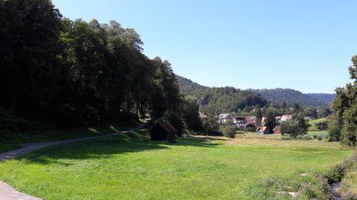 a grass field with a barn in the middle of a field at Nashira Kurpark Hotel in Bad Herrenalb