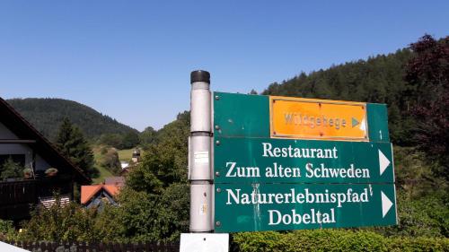 a green street sign on a pole in the mountains at Nashira Kurpark Hotel in Bad Herrenalb