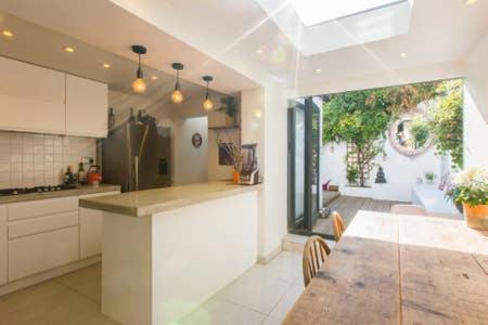 a kitchen with a table and a dining room at Regency Cottage in Brighton & Hove