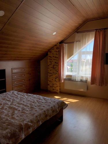 a bedroom with a bed and a large window at Villa Costa in Sanzhiyka