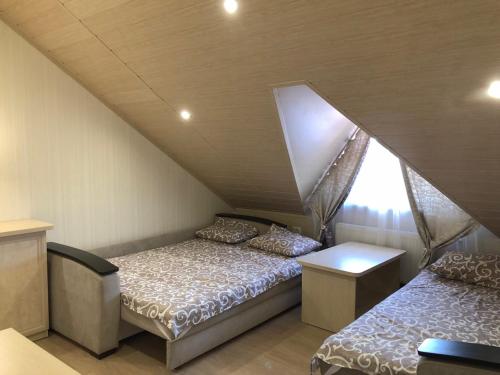 a room with two beds and a window in a attic at Villa Costa in Sanzhiyka