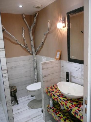 un baño con lavabo y un árbol en la esquina en B&B DINAN la priquetais en Trévron