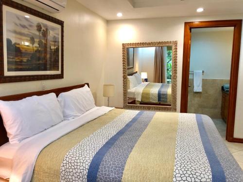 a bedroom with a large bed and a mirror at Monte Carlo Luxury Condominiums in Jacó