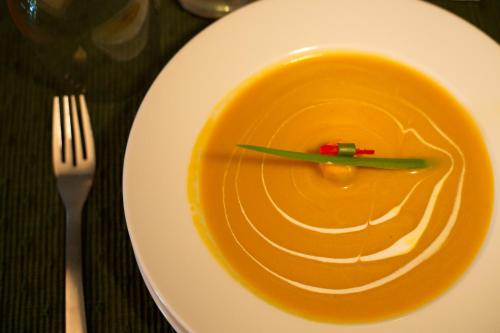 a plate with a green chopstick in a bowl of soup at Tea Bungalow in Cochin