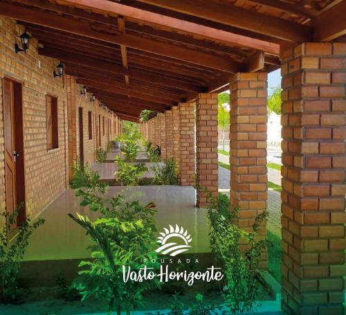 a brick building with a row of walkways with plants at Pousada Vasto Horizonte in Barreirinhas