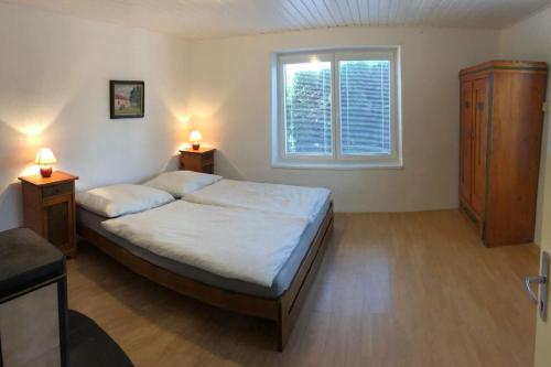 a bedroom with a bed and two night stands and a window at Adela´s Czech Village House in Všejany