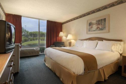a hotel room with a large bed and a television at Economy Inn & Suites in Shreveport