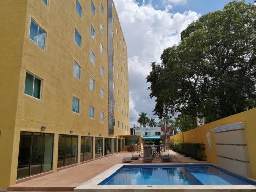 ein Gebäude mit einem Pool neben einem Gebäude in der Unterkunft Misol-Ha Hotel Mérida in Mérida