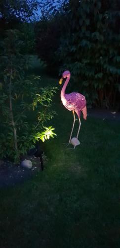 a statue of a pink bird standing in the grass at The Vine B & B in South Thoresby