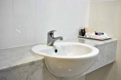 a white bathroom sink with a faucet on a counter at Brisbane International Virginia in Brisbane