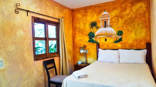 a bedroom with a bed and a clock tower on the wall at Argueta Hotel in San Luis