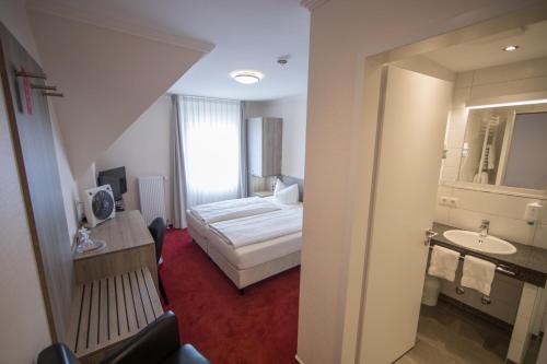 a hotel room with a bed and a bathroom at Altes Landhaus in Lingen
