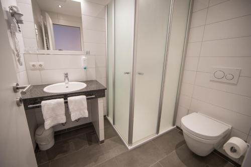 a white bathroom with a toilet and a sink at Altes Landhaus in Lingen