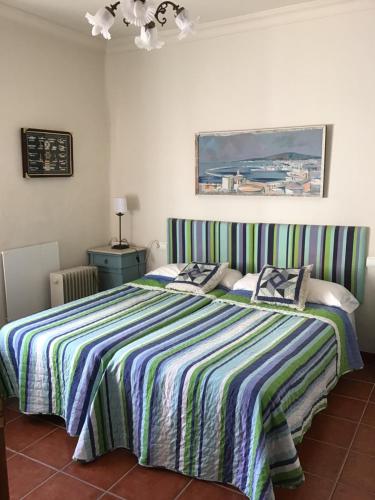 a bedroom with a bed with a striped blanket at Villa Rosario in Torre de Benagalbón