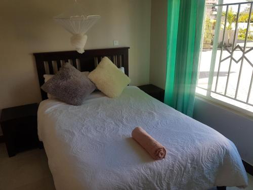 a bedroom with a bed with a towel on it at JMV apartments in Kasama