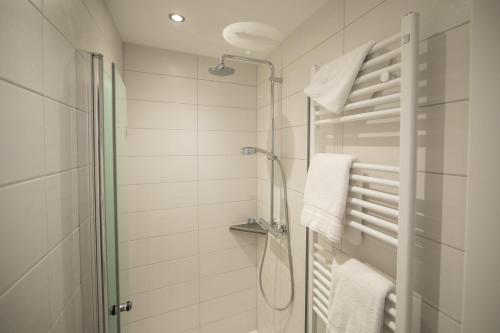 a white bathroom with a shower and towels at Altes Landhaus in Lingen