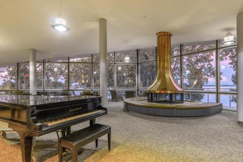 a room with a piano and a large window at Kentucky Dam Village State Resort Park in Gilbertsville