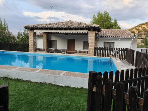 a house with a swimming pool next to a fence at Casa Esteban in Cazorla