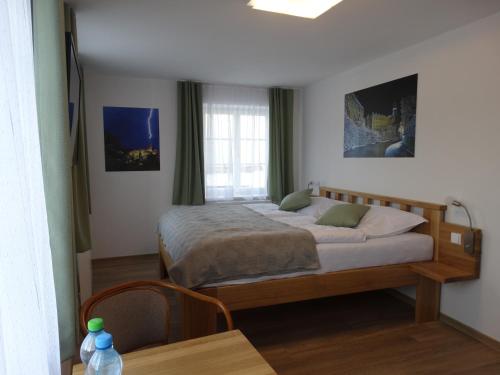a bedroom with a bed and a table in it at Hotel Garni Villa Areka in Český Krumlov