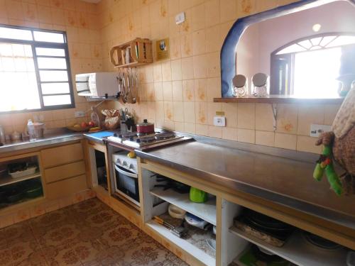 a kitchen with a sink and a counter top at Hostel Na Praia - Hospedagens e eventos in Ubatuba