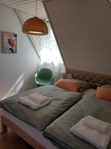 1 dormitorio con 2 camas y silla verde en Schöne, helle FeWo für 4 Personen en Ettenheim