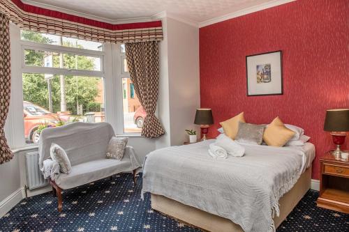a bedroom with two beds and a chair and a window at Crystal Hotel & Savour in Cambridge
