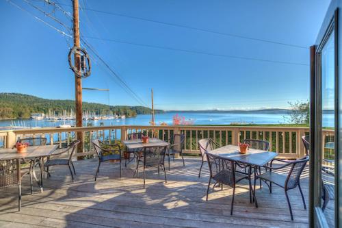 a deck with tables and chairs and a view of the water at Kingfish at West Sound in Eastsound