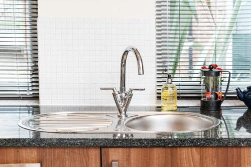 a kitchen counter with a sink in a kitchen at Central Durham Riverfront Apartment in Durham