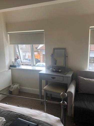 a bedroom with a desk and a mirror and a couch at Worthing Rest in Worthing