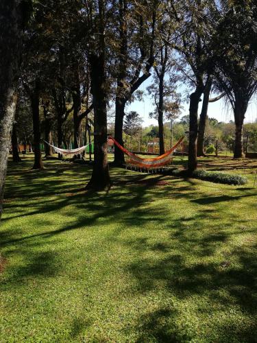 a hammock in a park with trees and grass at Encanto Rural in Bella Vista