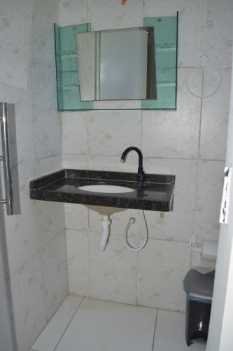 een badkamer met een wastafel en een spiegel bij Loura Pousada in Sobral