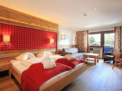 キルヒベルク・イン・チロルにあるホテル アレキサンダーの赤い壁のベッドルーム1室(大型ベッド1台付)