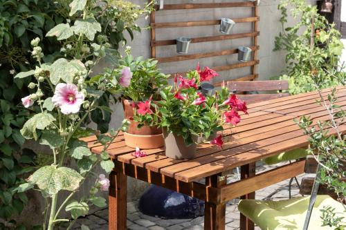 a wooden table topped with flowers and plants at An der Gose - Gästezimmer & Appartement in Goslar