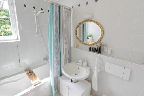 a white bathroom with a sink and a mirror at An der Gose - Gästezimmer & Appartement in Goslar