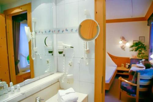 ein Bad mit einem Waschbecken und einem Spiegel in der Unterkunft Hotel Restaurant Rengser Mühle in Bergneustadt
