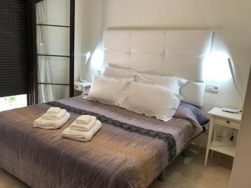 1 dormitorio con 1 cama con 2 toallas en Penthouse Karina Los Arqueros, en Benahavís