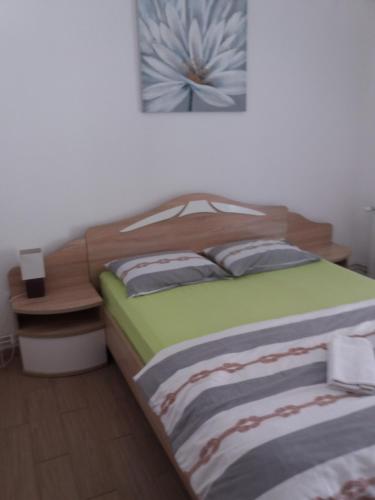 a bedroom with a bed with a wooden head board at Rooms Natalija in Sveti Juraj