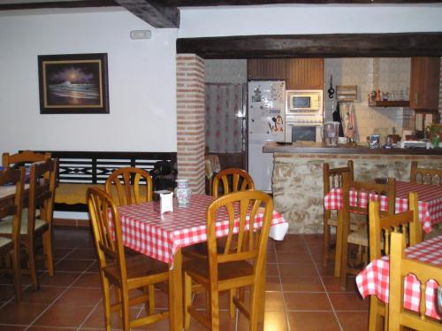 a dining room with a table and chairs and a kitchen at Casa Rural La Posada Del Frances in Villarrubia de Santiago