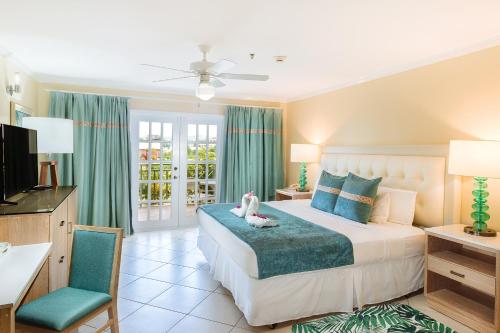 格罗斯岛Bay Gardens Beach Resort & Spa的一间卧室配有一张床、一张书桌和一台电视。
