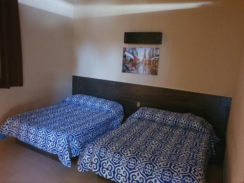 - deux lits assis l'un à côté de l'autre dans une pièce dans l'établissement Costa Miramar, à Acapulco