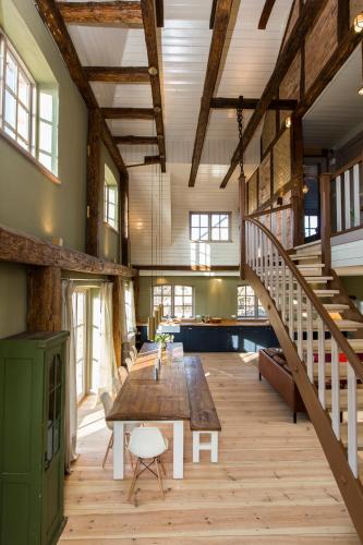 a large room with a wooden table and stairs at Gutshaus Lexow in Lexow