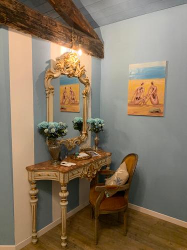 a dressing table with a mirror and a chair at Il Giardino Segreto Arona, Charming Apartments in Arona