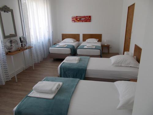 Un grupo de 4 camas en una habitación en La Maison Lydia en Moissac